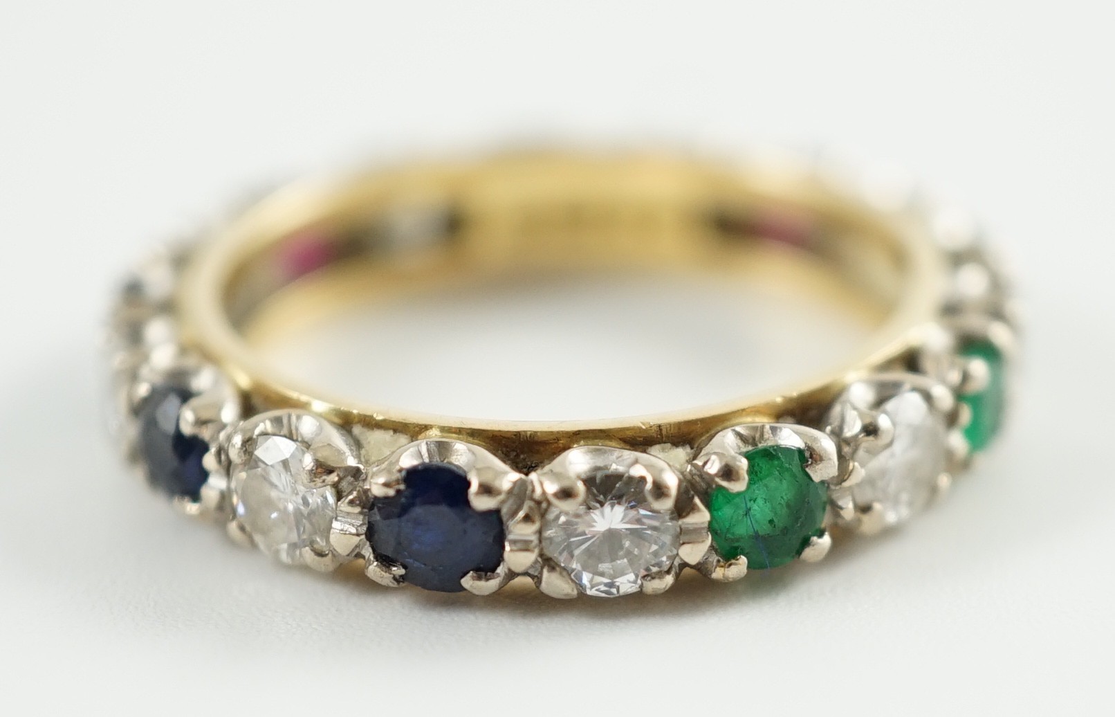 A modern 18ct gold, emerald, sapphire, ruby and diamond set full eternity ring